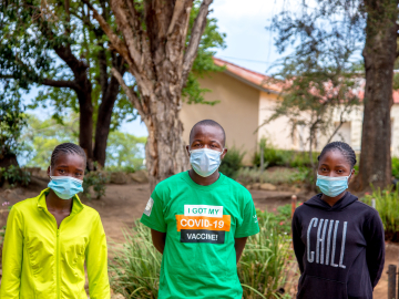 sther Sambiri, left, stands with fellow vaccine advocates outside the Nyanga, Zimbabwe, district government office on Dec. 16, 2021. Image: Farai Mutsaka