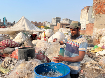 Mohammad Hanif washes recyclable materials pulled from the Bhalswa landfill in Delhi, on October 5, 2022. Image by Cheena Kapoor