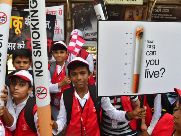 Children hold signs and giant paper cigarettes emblazoned with &quot;No Smoking&quot; to raise awareness of the harms caused by tobacco products on World No Tobacco Day. Mumbai, India, May 31, 2022.