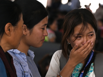 A woman cries as she waits at the Imphal airport to flee ethnic violence in the northeastern Indian state of Manipur on May 7, 2023.