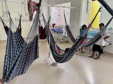 Yanomami Indigenous people rest in traditional blue and white hammocks used in lieu of hospital beds.