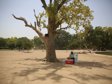 A man takes rest from selling water bottles on a hot afternoon near India Gate in Delhi.
