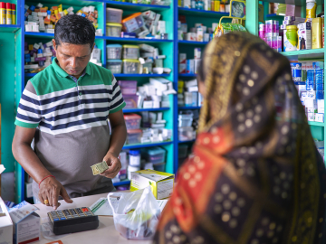 A pharmacist attends to a customer in an Indian pharmacy.