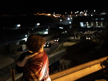 A young boy from Ceuta observes the entrance of the Tarajal beach, border between Morocco and Spanish territory of Ceuta on May 19, 2021.