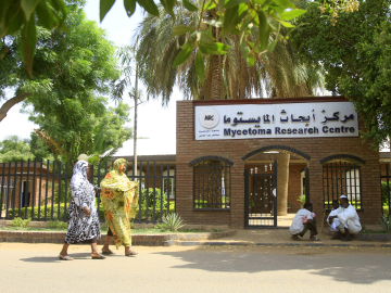 Two women pass by the Mycetoma Research Center in Khartoum, Sudan, before its 2023 destruction during the country’s civil war.