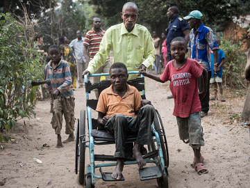 Etienne Tshiluanjim, 28, center in the wheelchair, leaving the Tomisa clinic in Kahemba with a group of children also suffering from konzo