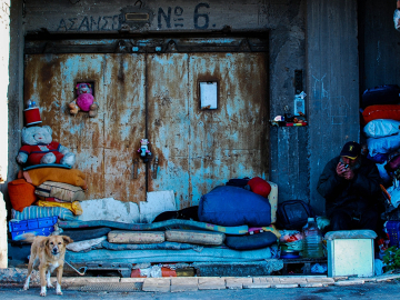 A homeless man sits under shelter at Pireus Harbour, Athens, Greece.