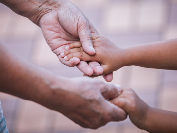 Grandmother and child holding hands; Thailand
