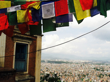 Prayer flags fluttering above Nepal. Image Courtesy of Emaline Laney.