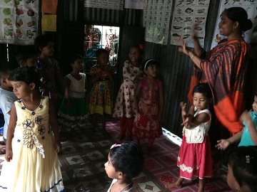 A day in an anchal: Children sing and dance to a Bangla rhyme along with their crèche mother.
