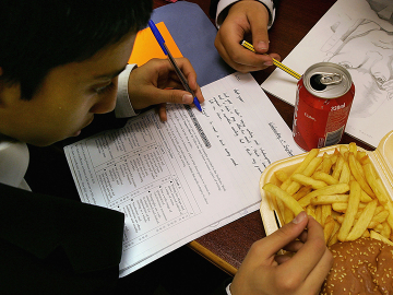 A London school student eats a hamburger and chips as part of his lunch which was brought from a fast food shop near his school, on October 5, 2005 in London, England.