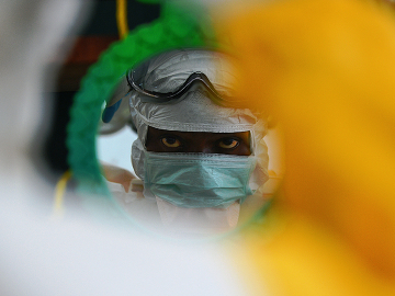 An MSF medical worker checking protective clothing in a mirror at an MSF facility in Kailahun, at the epicentre of the world's worst Ebola outbreak, in August 2014.
