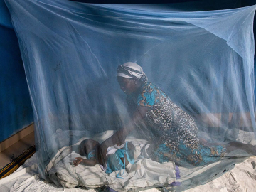 A woman with a child and a bednet.