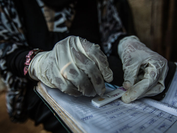 Habiba Suleiman, 29, a district malaria surveillance officer, records the results of a rapid diagnostic test for malaria at a home visit in Zanzibar, January 28, 2015.