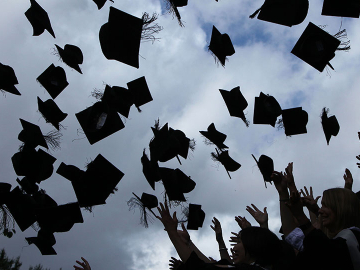 Graduating students toss their caps in the air