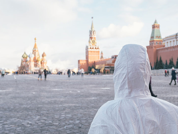 Person in PPE looks out over Red Square, Moscow. Shutterstock