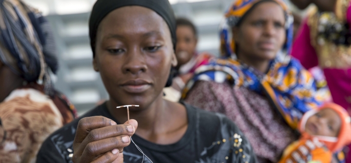 A woman holds up a contraceptive implant during Marie Stopes mobile clinical outreach team visit to a hospital in Rabai, Kenya. June 16, 2014.
