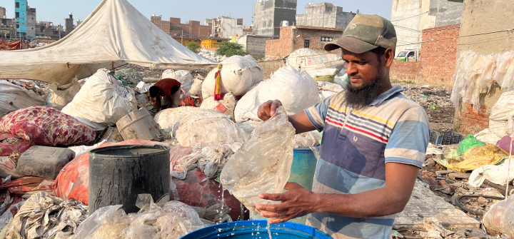 Mohammad Hanif washes recyclable materials pulled from the Bhalswa landfill in Delhi, on October 5, 2022. Image by Cheena Kapoor