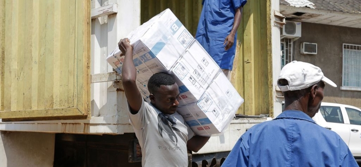 3 workers unload boxes of vaccines from a truck in Bujumbura, Burundi.
