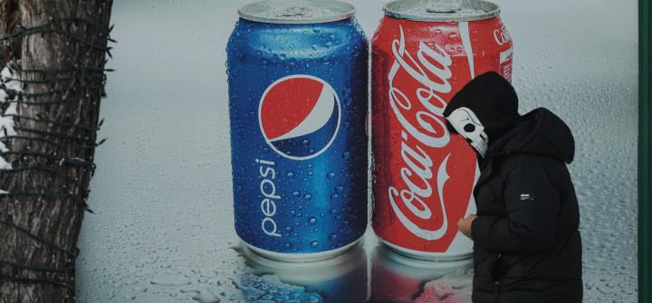 A man wearing a skull face mask walks past a Pepsi and Coca-Cola ad in the center of Edmonton, Alberta, Canada. December 30, 2021. 