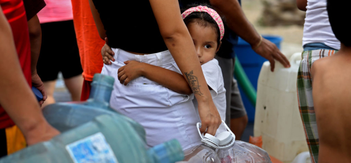 A young girl waits in line for not potable water delivered by a tanker truck in Colonia Mirador de Garcia, northwest of Monterrey, Mexico. July 19, 2022.