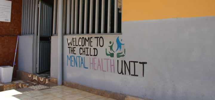 Yellow and gray building with the words "welcome to the mental health unit" painted on them.