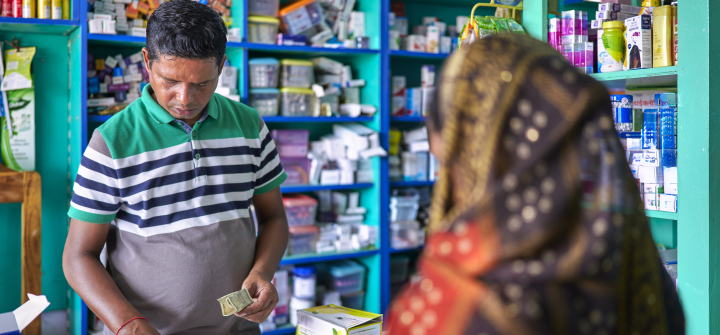 A pharmacist attends to a customer in an Indian pharmacy.