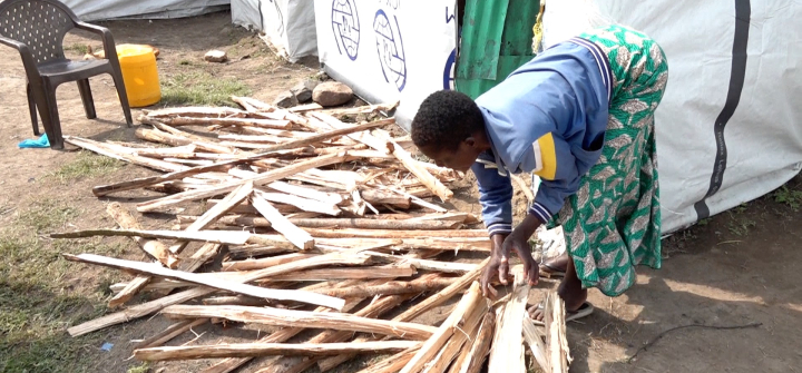 Hellen Anyango sorting a stash of firewood, which she occasionally sells to help support her four children. Nduru camp, Kisimu City, Kenya.