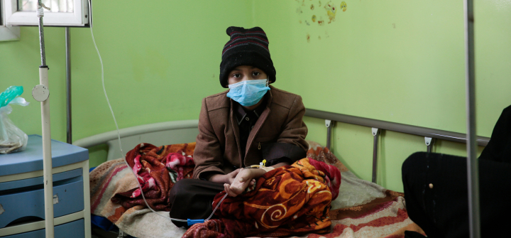 A boy who has cancer, sits on a bed as he receives treatment at the Oncology Centre in Sanaa, Yemen.