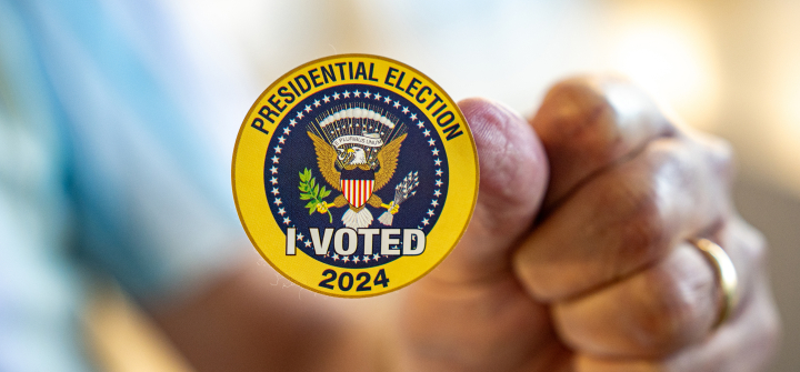 A man holds up a sticker that reads "Presidential Election I Voted 2024" on the first day of Virginia's in-person early voting at Long Bridge Park Aquatics and Fitness Center on September 20, 2024, in Arlington, Virginia.