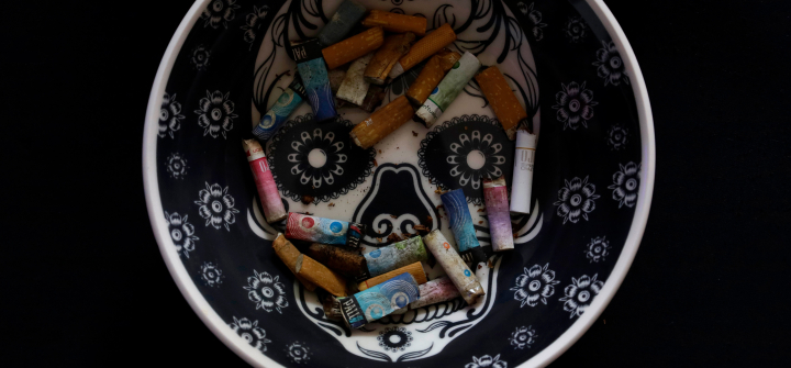 View of cigarette butts on an ashtray with an image of a sugar skull, in Mexico City. 