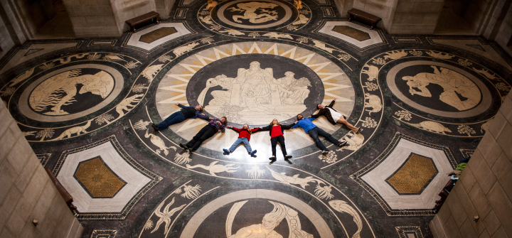 A tour group lies in a row on the decorative rotunda floor in the Nebraska State Capitol, in Lincoln, Nebraska.