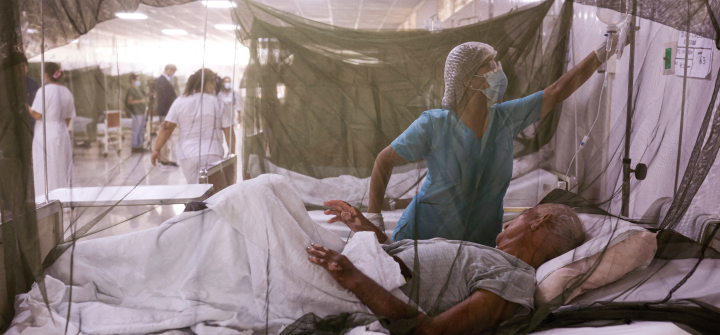 A nurse takes care of a dengue fever patient at the Sergio Bernales National Hospital, in the outskirts of Lima, Peru, on April 17, 2024.