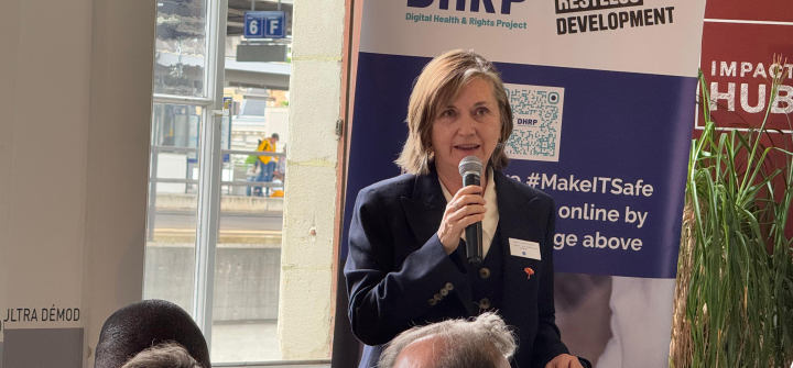 Photo of Professor Meg Davis holding a microphone and speaking before an audience for a sidebar event at the World Health Assembly.