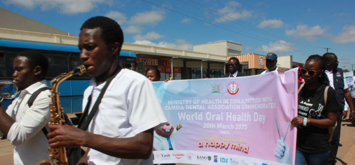 A saxophone player wearing a white t-shirt plays in a parade marking World Oral Health Day in Zambia.