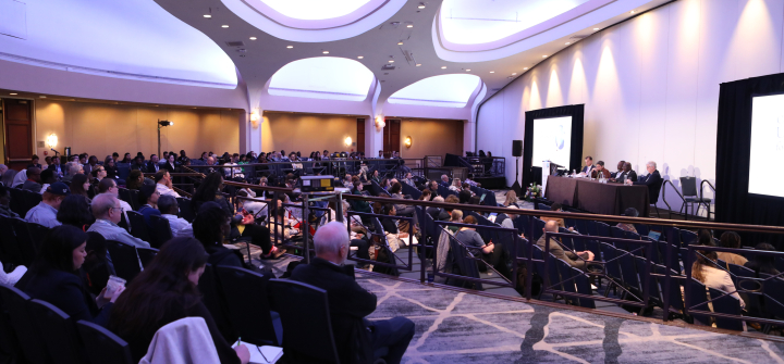 Panelists on the stage in a ballroom at the Washington, DC Hilton hotel, with a view of the audience from behind.