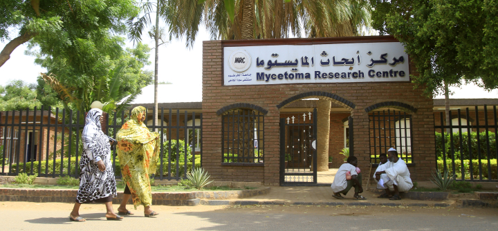 Two women pass by the Mycetoma Research Center in Khartoum, Sudan, before its 2023 destruction during the country’s civil war.