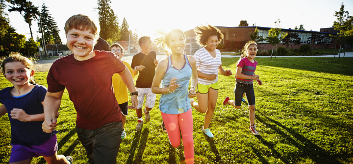 picture of children running towards camera in a field