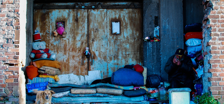 A homeless man sits under shelter at Pireus Harbour, Athens, Greece.