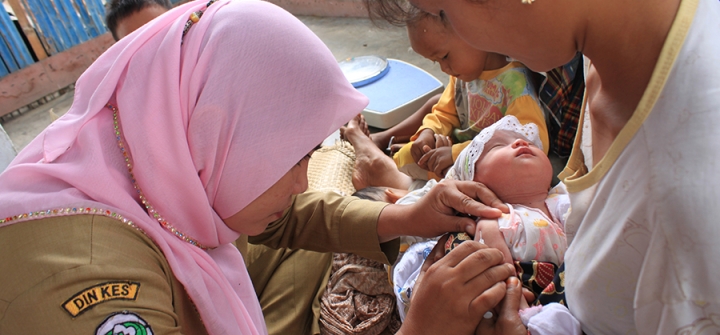 A health worker vaccinates an infant at a government health clinic in Desa Sigalapanag Julu, Indonesia. 
