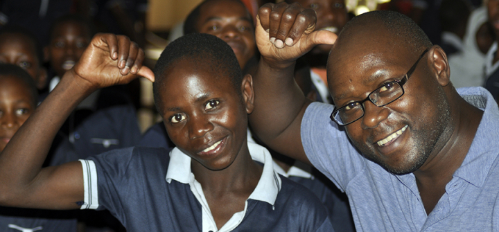 A deaf Tanzanian American and a student in a deaf unit in Tanzania signing their identical "sign names." Image/Amabilis Batamula