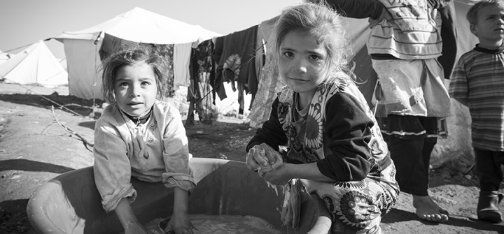 Syrian girls wash clothes outside their tent in the displaced persons camp in Atmeh, Syria in 2013.