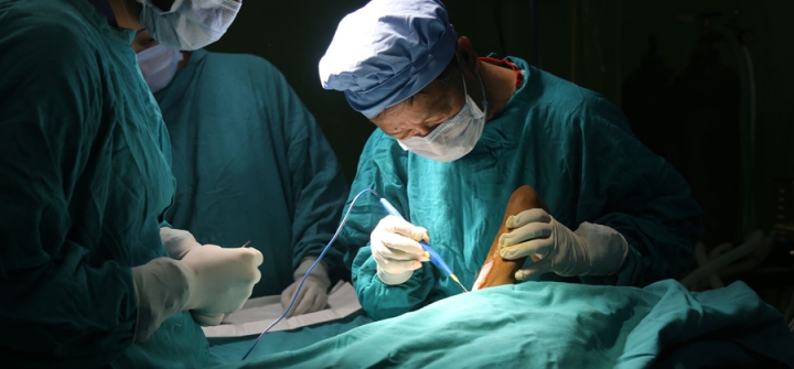 Dr. Shankar Man Rai taking a skin graft in a Nepal operating room.