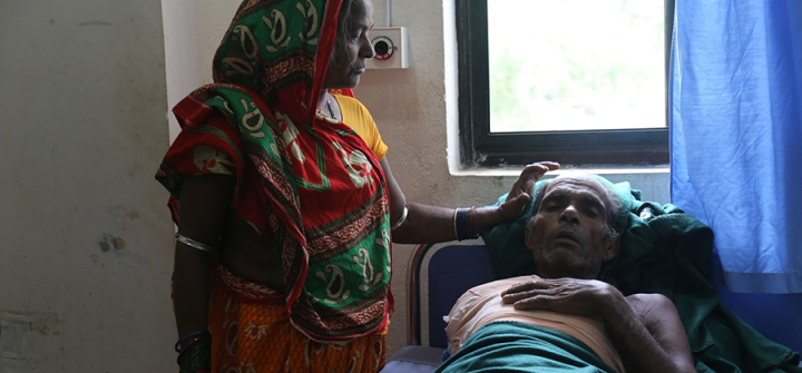 Urmila Devi Poddar stands beside her husband Ladayan Poddar, who accidentally touched a live wire and suffered burns so severe that his right arm had to be amputated. 