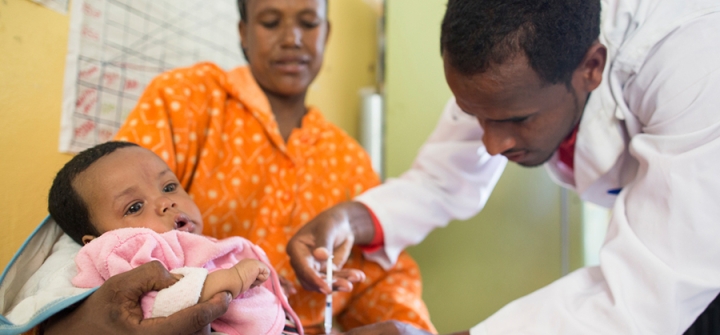 Mifta Mohammed gives a PCV vaccine to 5-month-old Tesfahun Tekilo as her mother Aberash Girm holds him at Dalocha Health Center in Kebet, Ethiopia. March 28, 2013.
