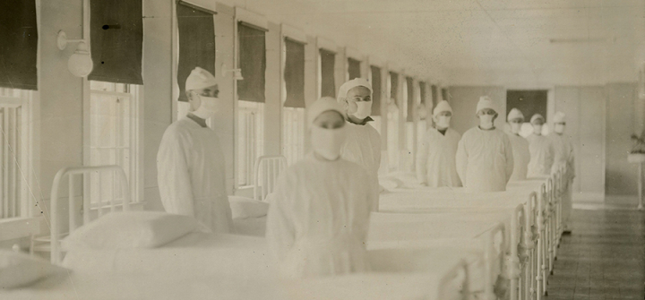 Corpsmen in cap and gown ready to attend patients in influenza ward of US Naval Hospital in Mare Island, California,  December 10, 1918. Wikimedia Commons/Public Domain.