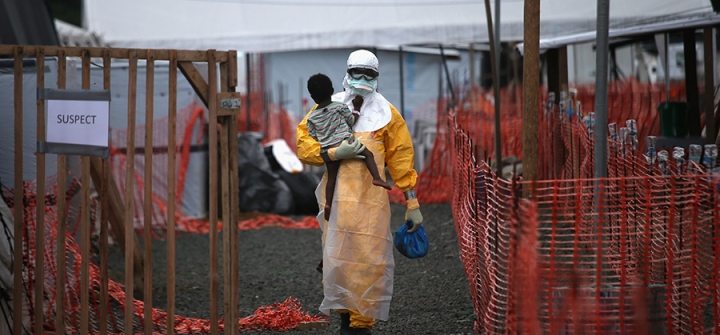 A Médecins Sans Frontières health worker carries a child suspected of having Ebola in the MSF treatment center on October 5, 2014 in Paynesville, Liberia.