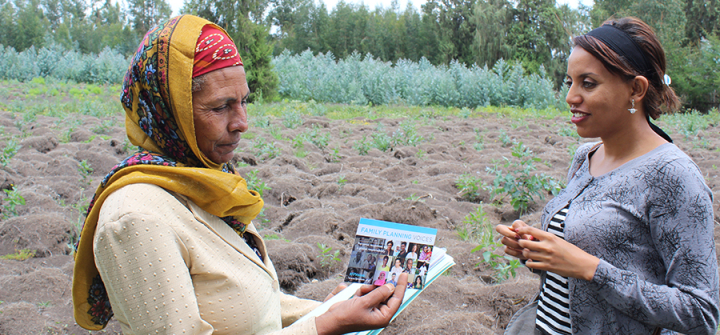 A worker with the PHE-Ethiopia Consortium, right, shares information with a schoolteacher in the rural Bale-Eco region. 