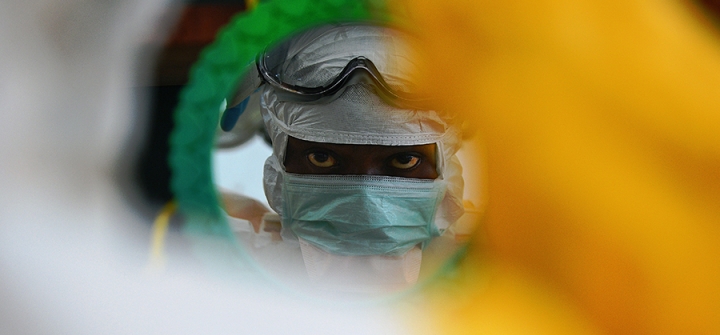 An MSF medical worker checking protective clothing in a mirror at an MSF facility in Kailahun, at the epicentre of the world's worst Ebola outbreak, in August 2014.
