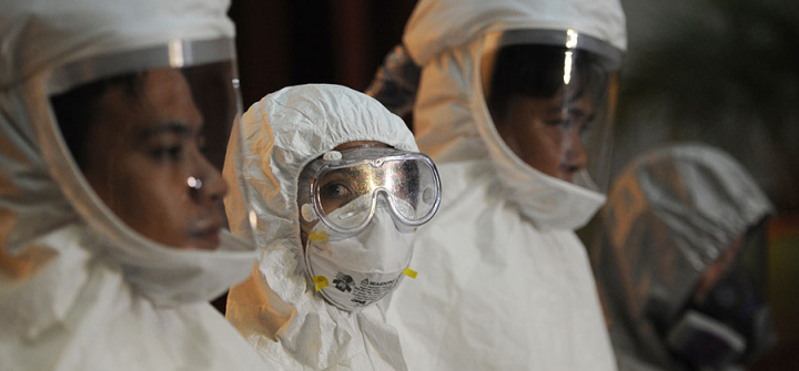 Philippine medical workers donned protective suits during a press conference by health officials on the country's preparedness against Ebola on October 21, 2014. Image: Ted Aljibe/AFP/Getty